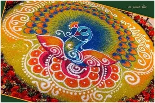 Peacock rangoli design on a yellow base and bordered with red roses