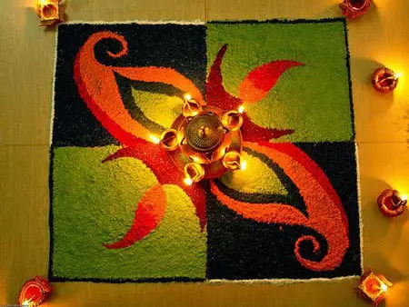 Freehand rangoli design decorated with diyas