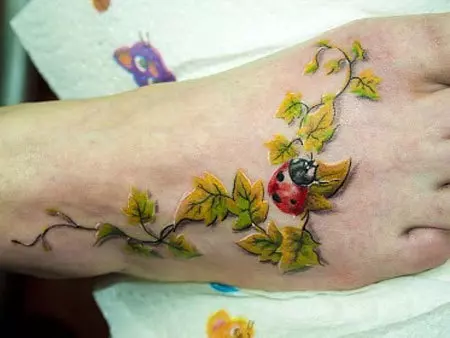 Ladybug on branch tattoo