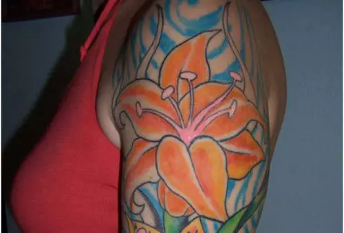 Orange lily on waves tattoo