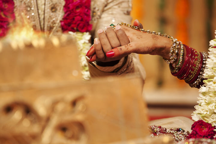 Close-up-of-groom-holding-brides-hand