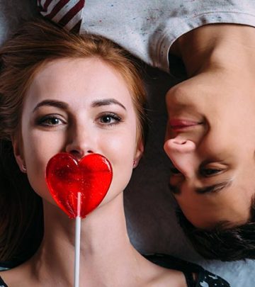 Loving-couple-lying-on-the-floor-girl-covers-her-mouth-with-a-lollipop