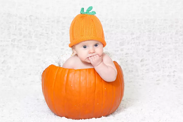 Knitted hat wearing baby in a pumpkin pictures