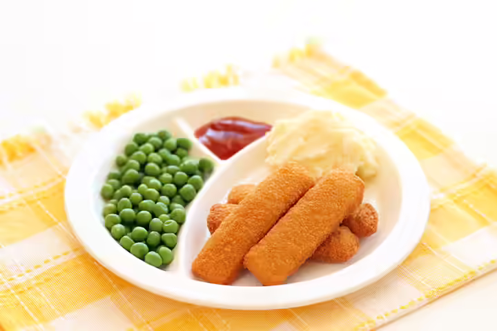 Baked fish fingers with mashed potatoes and green peas, school lunch idea for kids Baked fish fingers with mashed potatoes and green peas, school lunch idea for kids