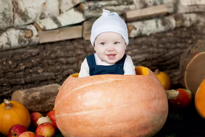 Wood and stone background with baby in a pumpkin pictures Wood and stone background with baby in a pumpkin pictures
