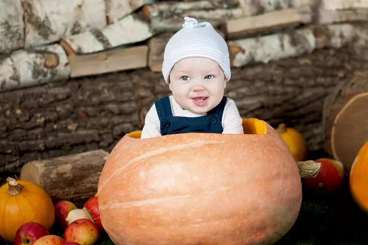 Wood and stone background with baby in a pumpkin pictures