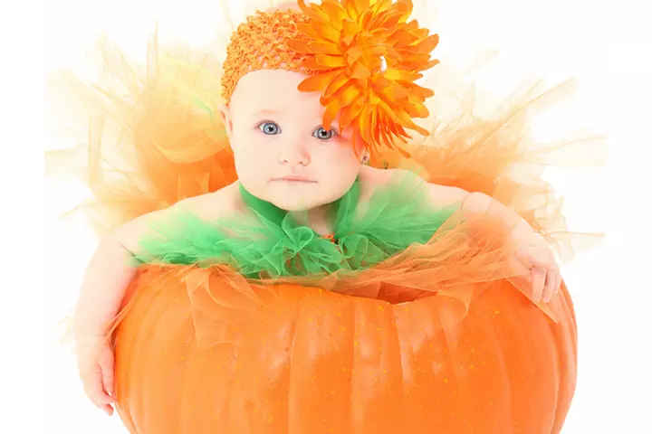 Add a costume to the baby in a pumpkin pictures