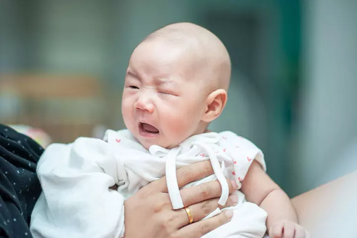 newborn-baby-crying-sitting-on-her