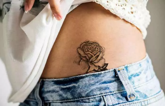 An individual showing off a healed tattoo on the hip