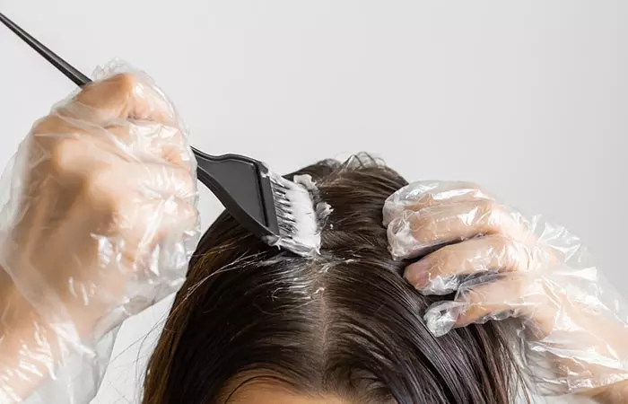 Woman dyeing her hair at home to obtain oil slick hair