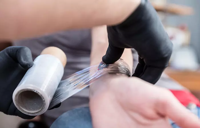 Tattoo artist wrapping the tattoo