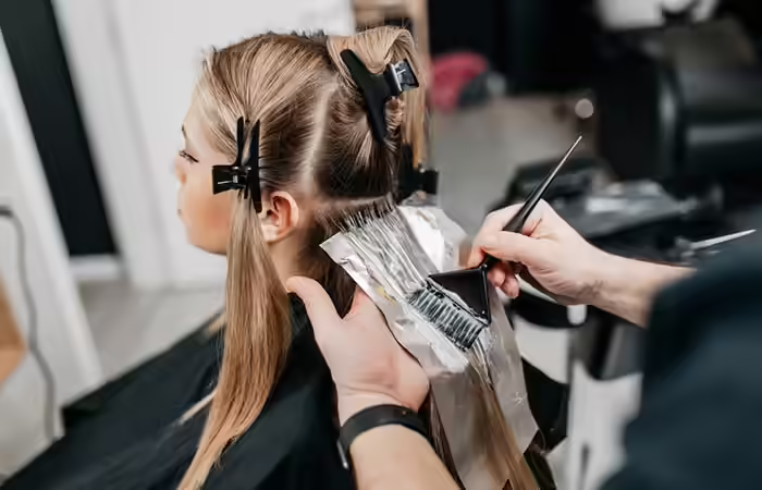 Woman lightening her hair to obtain oil slick hair