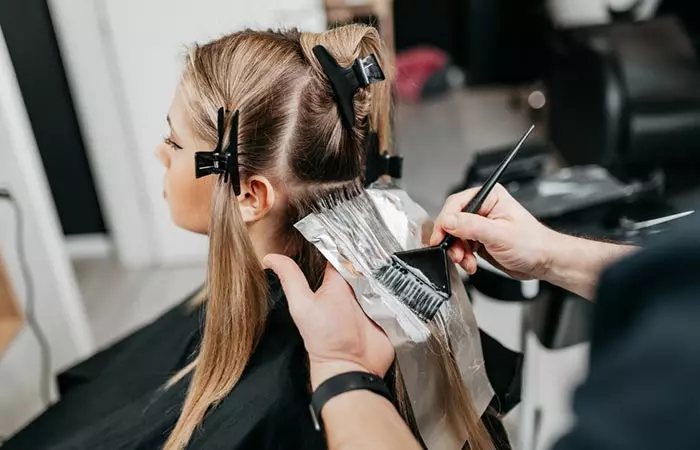 Woman lightening her hair to obtain oil slick hair