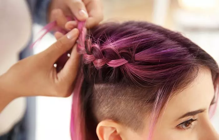 Woman styling her oil slick hair in braids