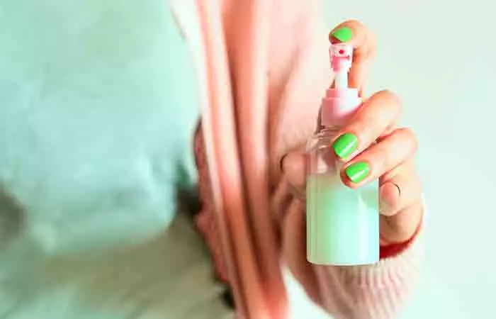 Woman holding a bottle of diluted castile soap shampoo