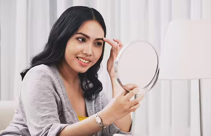 A woman happy with the results of her eyebrow procedure