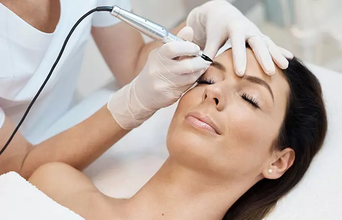 A woman getting a brow tattoo