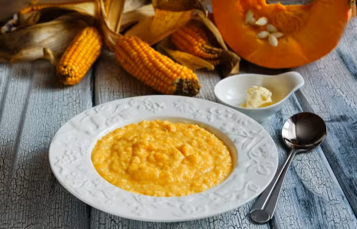 corn-pumpkin-porridge-on-white-plate-701827486