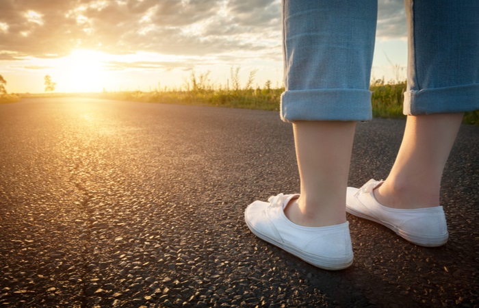 woman-white-sneakers-standing-on-asphalt-443056951