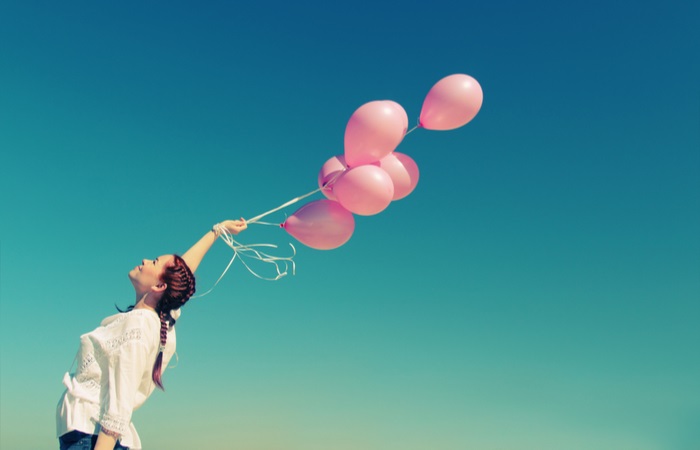 young-redhead-woman-holding-pink-balloons-176813414