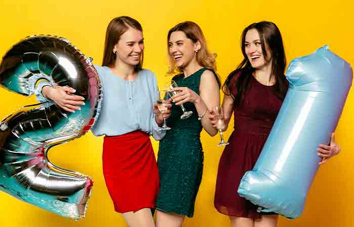 Girls holding 21st birthday party decor