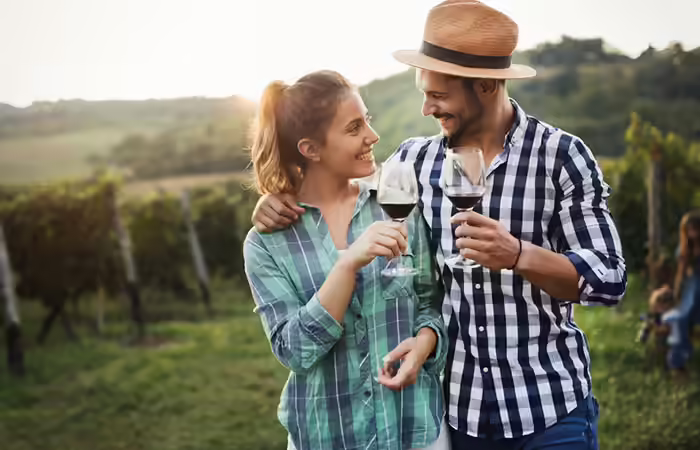 Couple in a vineyard having wine together Couple in a vineyard having wine together