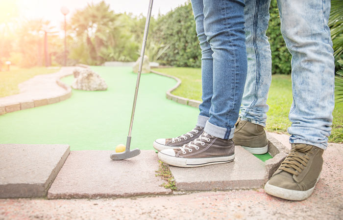 Couple playing mini golf