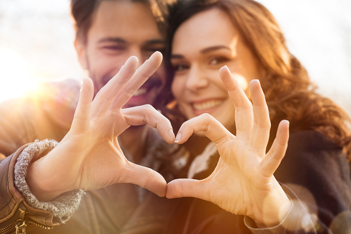 A couple in love making heart shape with hands