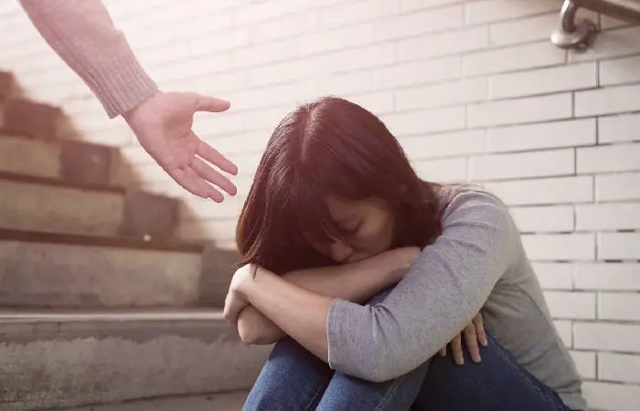 A depressed woman being offered a helping hand