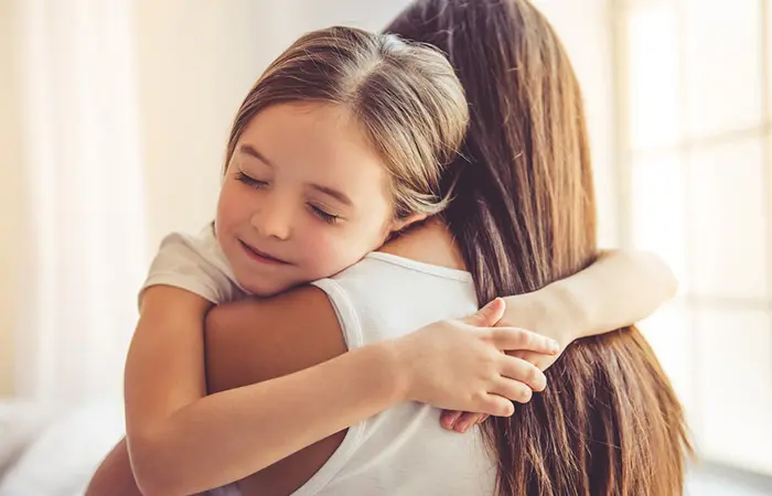 A girl child feeling less stressed after hugging her mom.