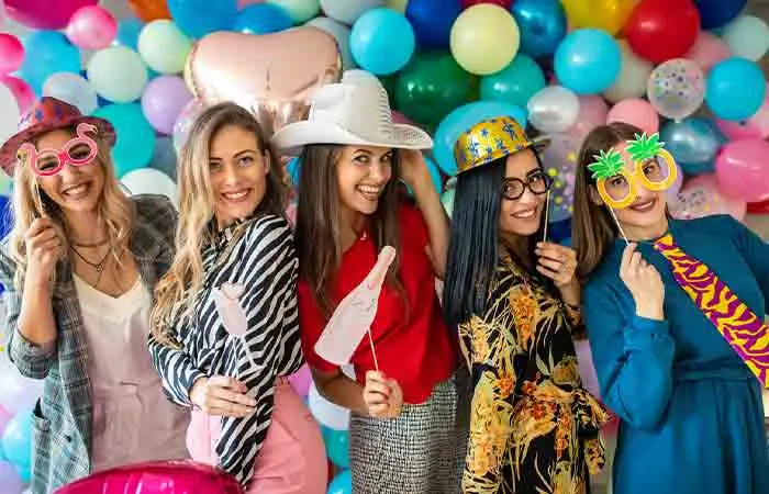 Girlfriends having fun at a bachelorette party decorated with colorful balloons