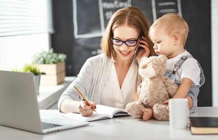 Mother pays attention to kid while working.