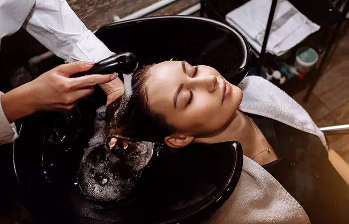 Woman enjoying a clarifying shampoo at salon