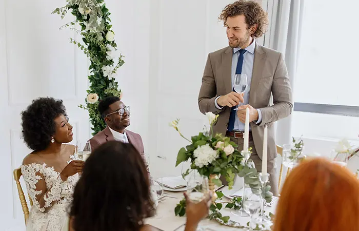 A young man giving a toast and speech at a wedding reception