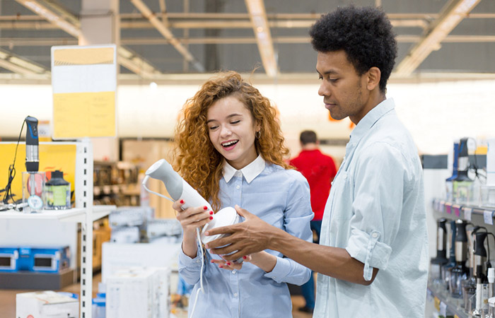 Couple checking a blender that can be included in a wedding registry checklist