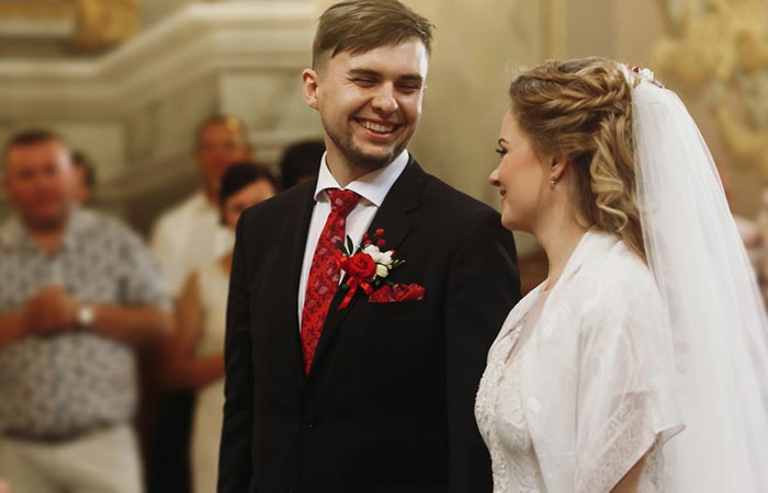 Bride and groom smiling at each other before the maid of honor's speech