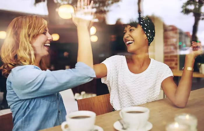 Two friends high-fiving each other