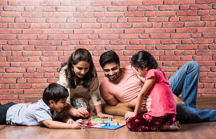 The family is playing ludo and enjoying it a lot.