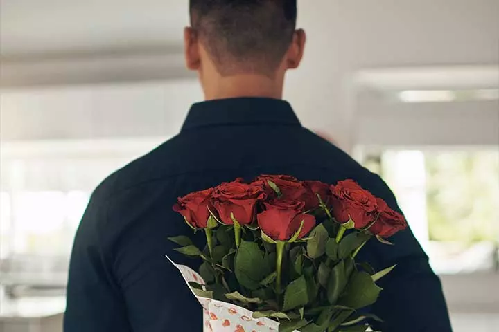 Man brings a bouquet of roses for his wife