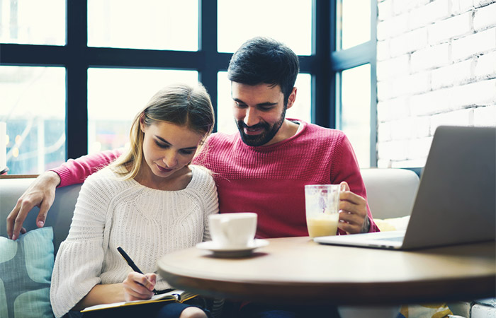 A couple at a cafe making the wedding registry checklist together