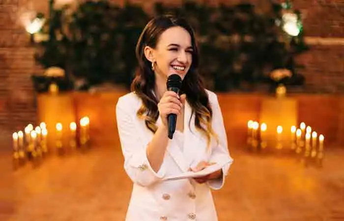 Woman speaking at party with cue card in hand