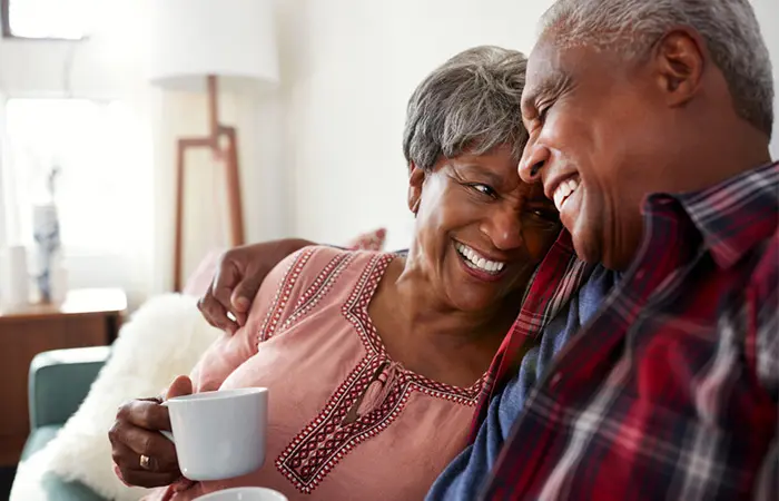 Two people smiling while giving each other a side hug.