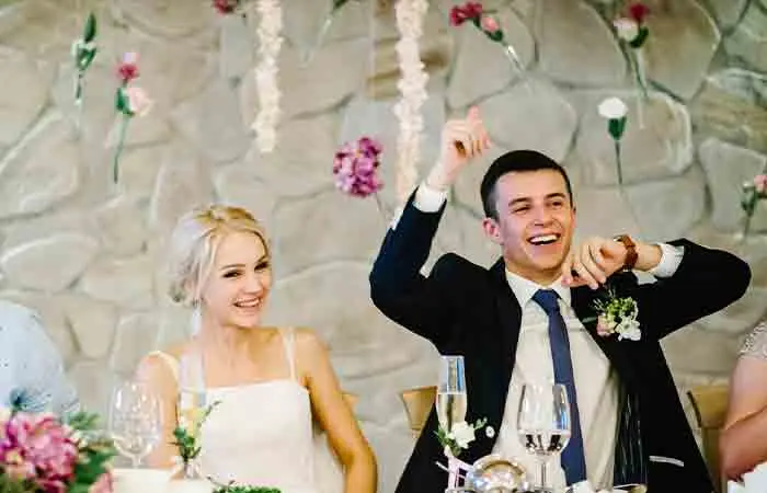 Bride and groom laughing seated side by side