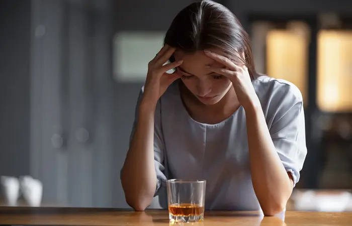 A fed up woman holding her head, thinking about her toxic relationship.